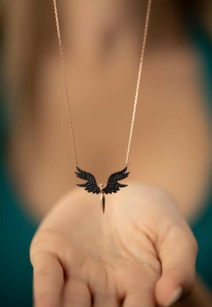 Bold winged necklace Avant-garde fashion Black and gold accent Edgy statement piece Distinctive jewelry